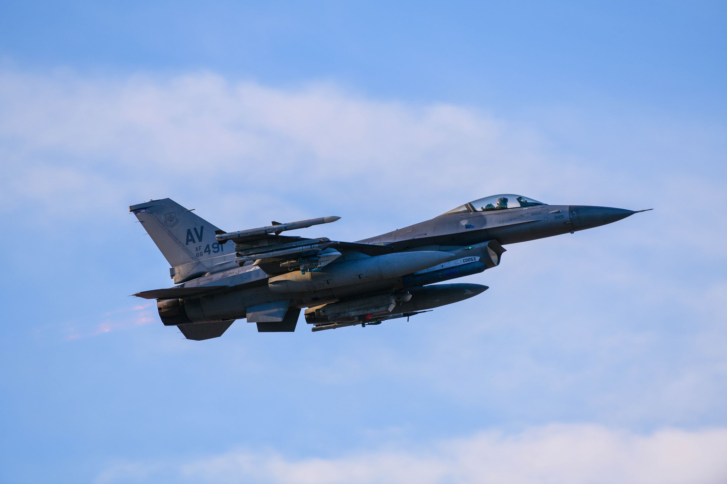 A 510th Fighter Squadron F-16 climbs out of Aviano with the snow-covered Alps behind it